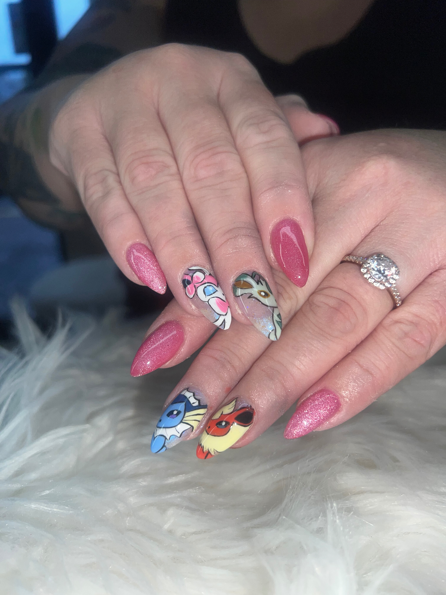 Pink glitter almond nails with hand-painted Eevee Pokémon characters